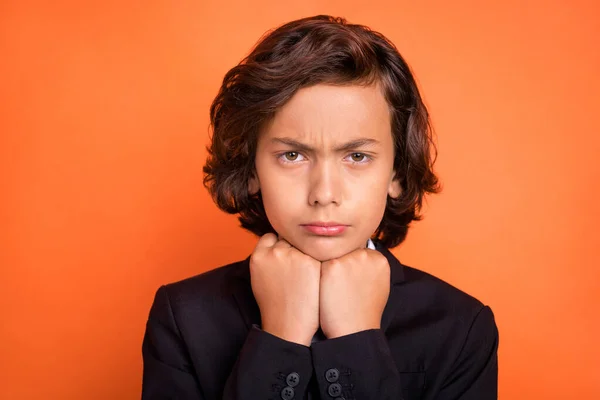 Photo of young unhappy upset sad boy hold hands chin face offended bad mood isolated on orange color background —  Fotos de Stock
