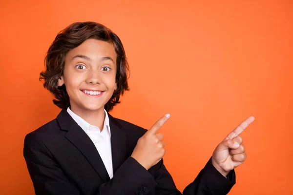 Фото молодого щасливого позитивного чарівного хлопчика вкажіть пальцем порожній простір гарний настрій ізольовано на помаранчевому кольоровому фоні — стокове фото