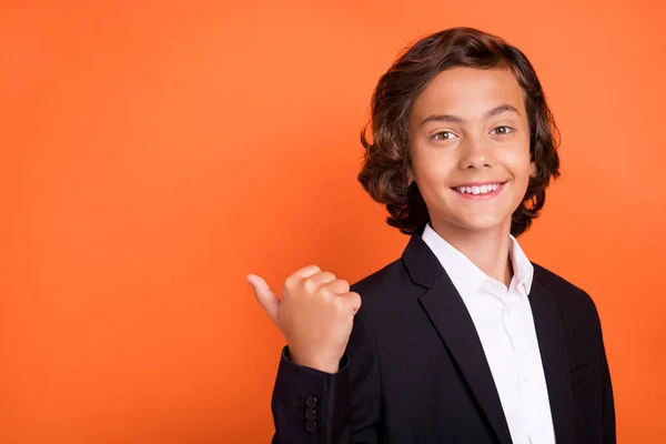 Foto von jungen charmant fröhlich fröhlich Junge Zeigefinger Daumen leer Raum Lächeln isoliert auf orangefarbenem Hintergrund — Stockfoto