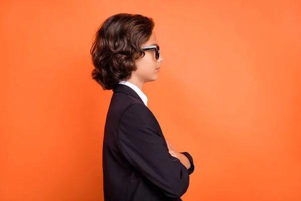 Profilseite Foto von glücklichen positiven Jungen aussehen leer Raum tragen Gläser isoliert auf orangefarbenem Hintergrund — Stockfoto