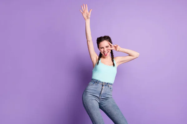 Photo of happy nice cheerful young woman stick out tongue make v-sign dance isolated on purple color background — 스톡 사진