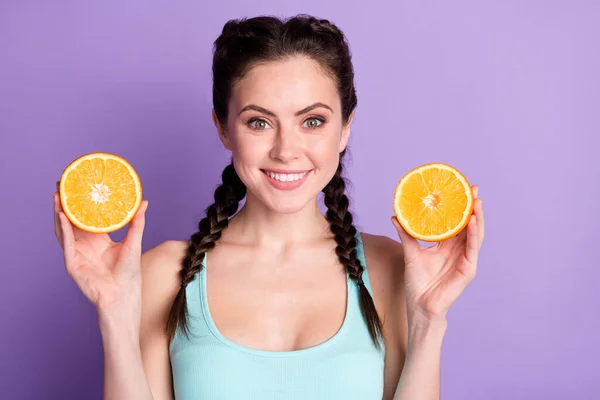 Portrait of attractive cheerful girl holding in hands orange juicy pieces isolated over violet purple color background —  Fotos de Stock