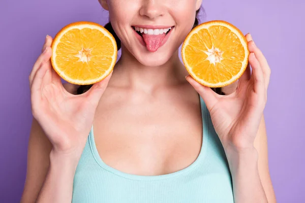 Обрізана фотографія красивої милої леді тримає апельсиновий язик у синьому верхньому одязі ізольовано на фіолетовому кольоровому фоні — стокове фото