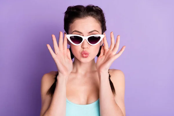 Φωτογραφία πορτρέτο της νεαρής γυναίκας που στέλνει φιλί αέρα φορώντας γυαλιά ηλίου απομονώνονται σε παστέλ μωβ φόντο χρώμα — Φωτογραφία Αρχείου