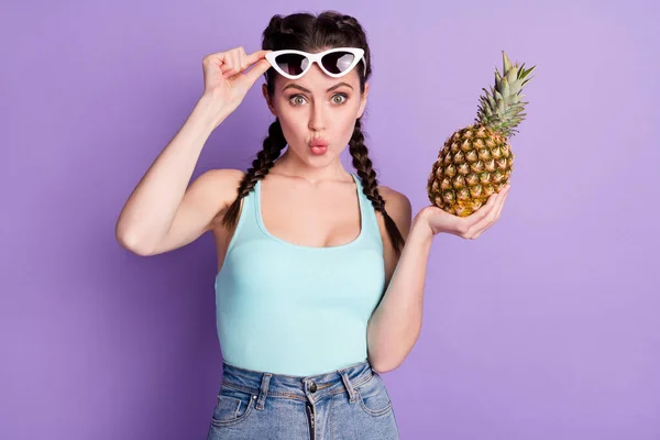 Portrait of attractive funny amazed girl holding on palm ananas rest pout lips isolated over violet purple color background — ストック写真