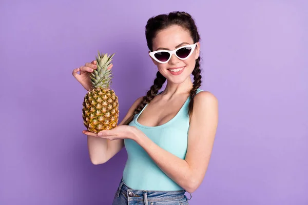 Portrait of cute cheerful brown hair lady hold pineapple wear spectacles blue top isolated on purple color background — Photo