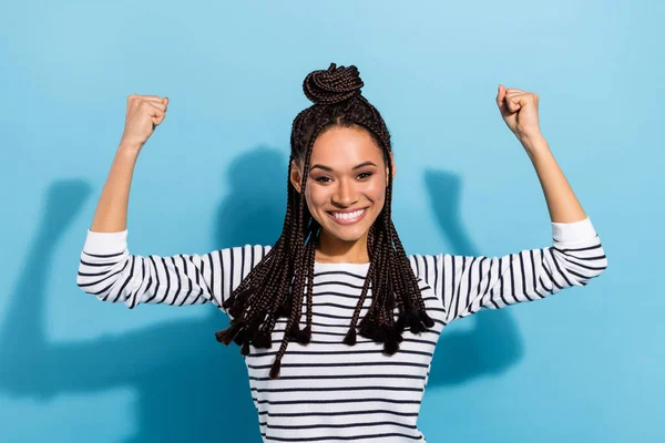 Foto av ung sportig svart flicka glad positiv leende visar armar muskler makt isolerad över blå färg bakgrund — Stockfoto