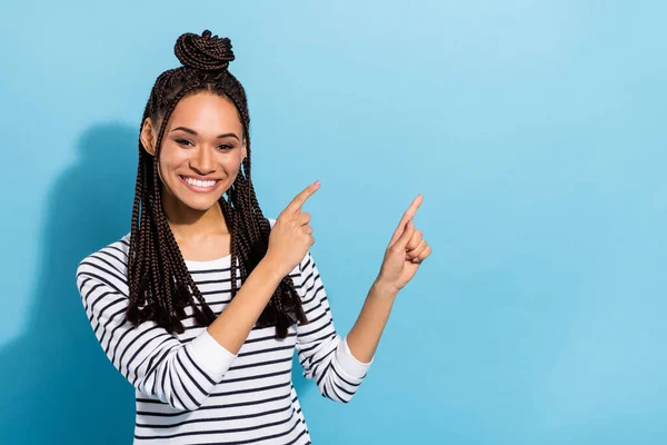 Foto av ung afro flicka glad positiv leende visar fingrarna tomt utrymme väljer föreslå promo isolerad över blå färg bakgrund — Stockfoto