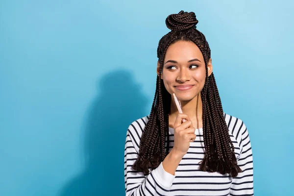 Foto av ung afro flicka glad positiv leende penna touch haka har idé ser tomt utrymme isolerad över blå färg bakgrund — Stockfoto