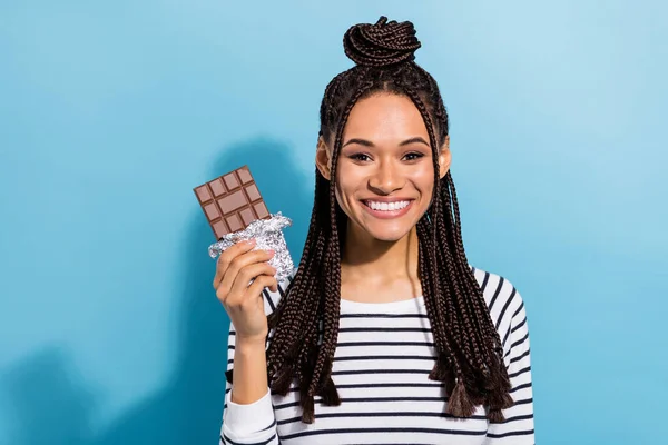 Foto van jong vrolijk Afrikaans meisje blij positief glimlach dieetsuiker zoete chocolade lekker geïsoleerd over blauwe kleur achtergrond — Stockfoto