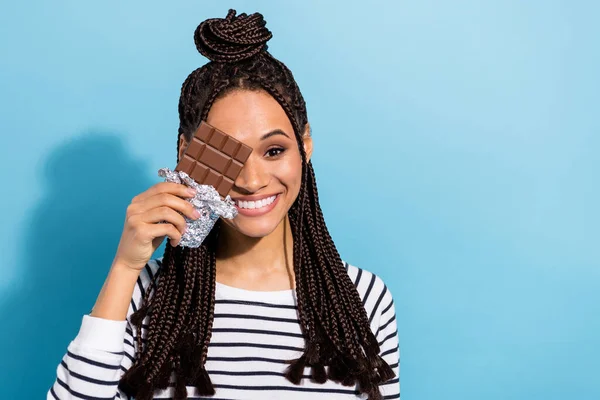 Photo of young attractive black girl happy positive smile cover eye chocolate sugar dieting isolated over blue color background — ストック写真