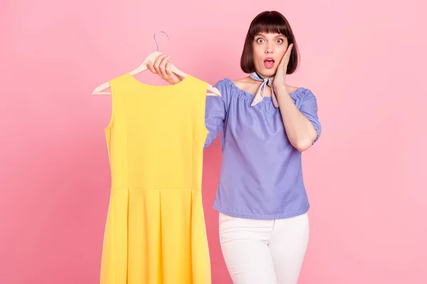 Photo portrait of pretty woman fitting clothes on shopping amazed high price isolated on pastel pink color background — Fotografia de Stock