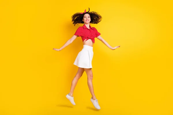 Фотографія профілю крутої оптимістичної брюнетки стрибок волосся леді носить червону спідницю верхньої смуги ізольовано на жовтому фоні — стокове фото