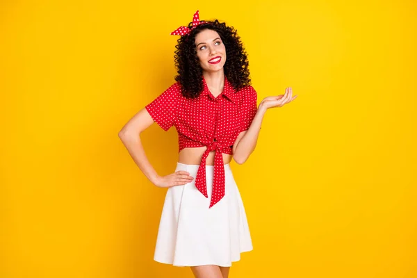 Foto de cabello morena optimista lindo señora mirada espacio vacío desgaste falda superior roja aislada sobre fondo de color amarillo — Foto de Stock