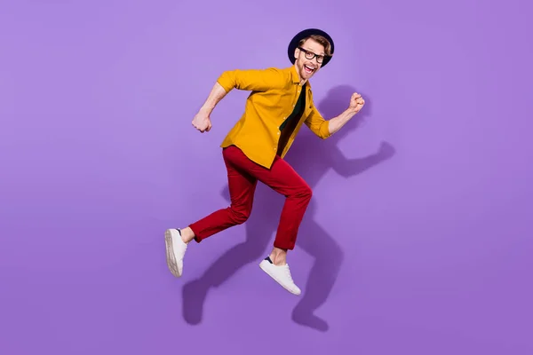 Full sida profil sida foto av ung kille glad positiv leende gå gå gå snabbt hoppa isolerad över lila färg bakgrund — Stockfoto