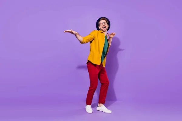 Full length φωτογραφία του αστείου funky happy man dance ματιά κενό χώρο φορούν καπέλο που απομονώνονται σε μωβ φόντο χρώμα — Φωτογραφία Αρχείου