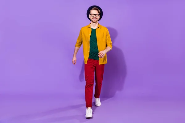 Lunghezza completa foto di giovane bell'uomo felice sorriso positivo andare a piedi passo isolato su sfondo di colore viola — Foto Stock