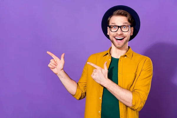 若い興奮した男の写真幸せな正の笑顔ポイント指空のスペース選択広告は紫の色の背景に孤立 — ストック写真