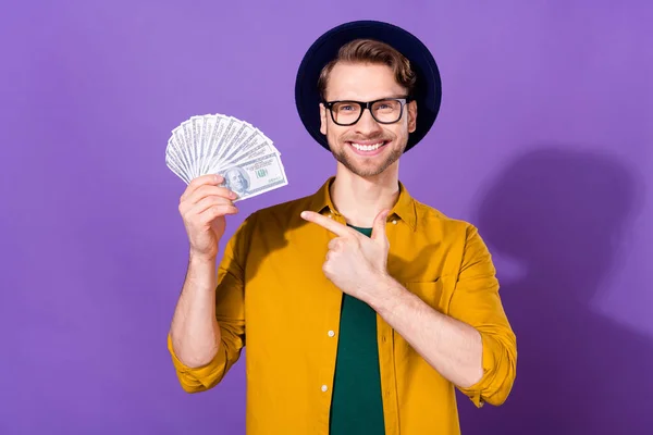 Retrato de cara alegre atraente segurando demonstrando economia de dinheiro fã isolado sobre fundo de cor roxo violeta brilhante — Fotografia de Stock