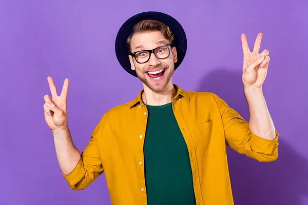 Фото молодого человека счастливая положительная улыбка показывают мир прохладно V-знак изолирован на фиолетовом фоне цвета — стоковое фото