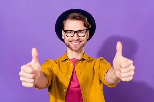 Photo de attrayant heureux joyeux jeune homme montrer pouces vers le haut conseils annonce isolée sur fond de couleur violette — Photo
