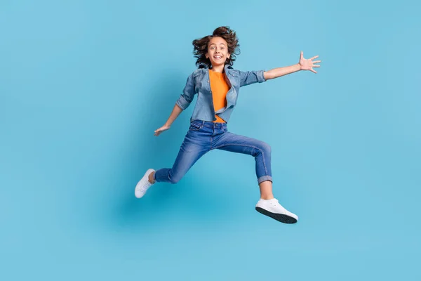 Foto de tamaño completo de niño alegre joven feliz sonrisa positiva divertirse salto aislado sobre fondo de color azul — Foto de Stock