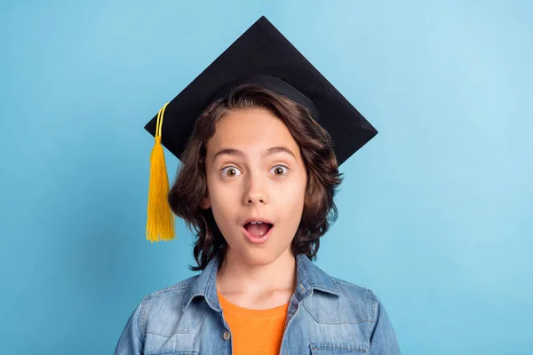 Foto di giovane preteen ragazzo felice sorriso positivo laureato college cappello nero isolato su sfondo di colore blu — Foto Stock