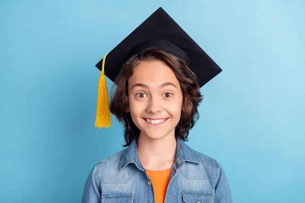 Photo de jeune garçon de l'école heureux sourire positif porter mortarboard étudiant isolé sur fond de couleur bleue — Photo