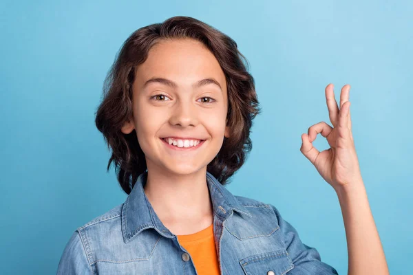 Foto von jungen preteen Junge glücklich positives Lächeln zeigen okay Zeichen Wahl große Promo isoliert über blauen Farbhintergrund — Stockfoto