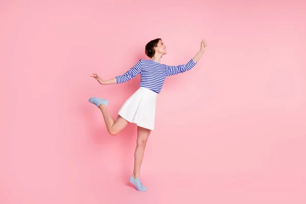 Foto de perfil de longitud completa de pie de niña de puntillas sujeción paraguas imaginado desgaste camisa a rayas mini falda aislado pastel rosa color fondo — Foto de Stock