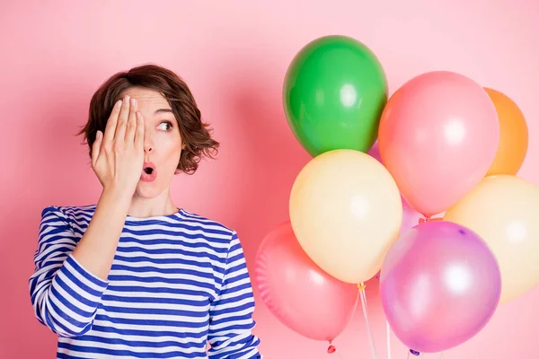 Retrato de joven hermosa sorprendida chica cubierta media cara mirada copyspace mantenga globos aislados sobre fondo de color rosa —  Fotos de Stock