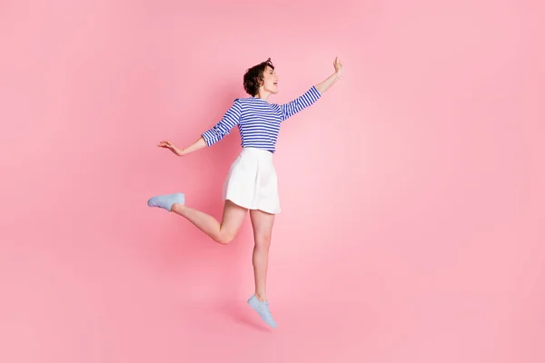 Foto lateral de perfil de tamaño completo de la joven hermosa chica loca emocionada salto mirada copyspace aislado sobre fondo de color rosa — Foto de Stock
