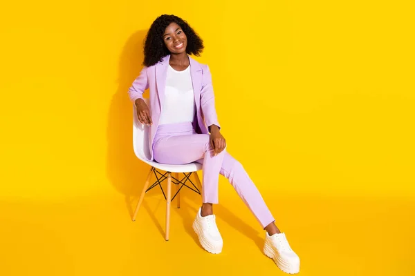 Full size photo of young beautiful charming cute afro businesswoman sit char relaxing isolated on yellow color background — ストック写真