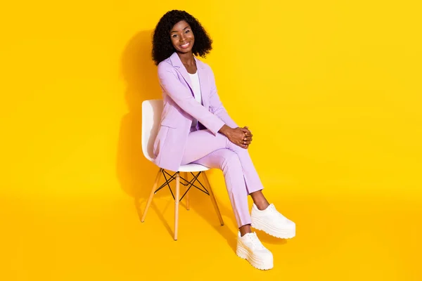 Photo pleine grandeur de jeune heureuse souriante belle afro femme d'affaires assise chaise isolée sur fond de couleur jaune — Photo