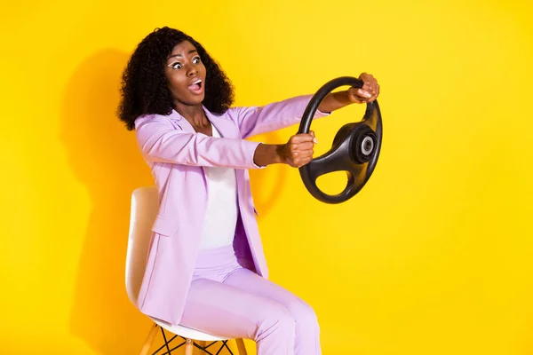 Photo de jeune surprise surprise afro femme conduite rapide tenir volant isolé sur fond de couleur jaune — Photo