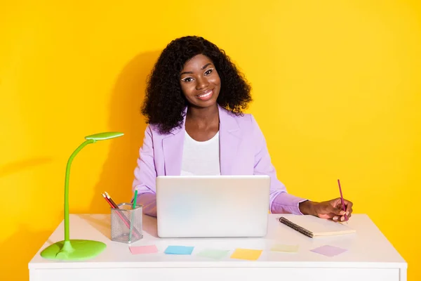 Foto von jungen glücklichen positiven lächelnden Afro-Frau arbeitet in Laptop-Schrift in Veranstalter isoliert auf gelbem Hintergrund — Stockfoto