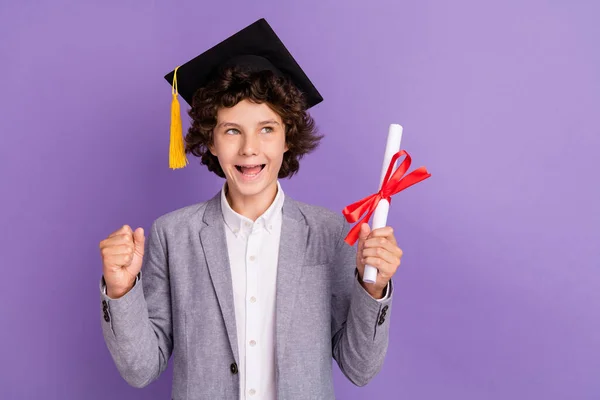 Foto av förvånad triumferande skolbarn hålla diplom titta tomt utrymme bära hatt grå kostym isolerad violett färg bakgrund — Stockfoto