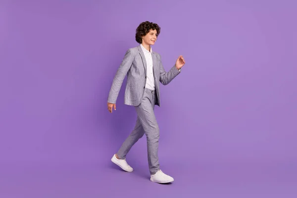 Profil foto av skolpojke student lockigt frisyr kille gå bära grå kostym isolerad violett färg bakgrund — Stockfoto