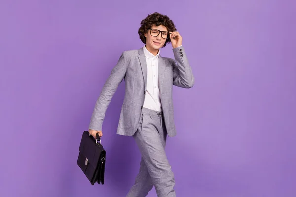 Foto di successo studente alunno ragazzo camminare strada portare caso indossare abito grigio isolato viola colore sfondo — Foto Stock