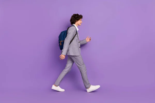 Profilo foto di concentrato scolaro passeggiata portare zaino indossare abito grigio isolato colore viola sfondo — Foto Stock