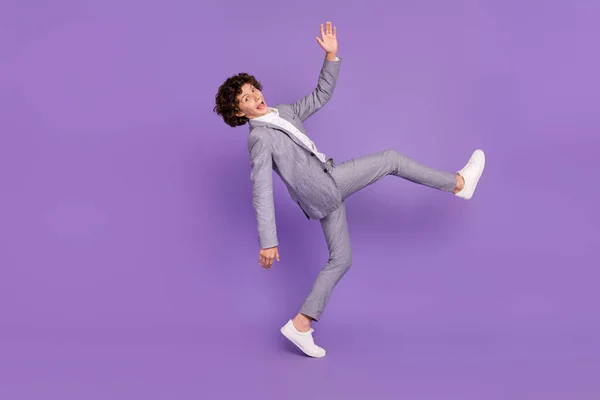 Foto di negligente pazzo studente ragazzo discoteca danza scherzare intorno indossare abito grigio isolato colore viola sfondo — Foto Stock