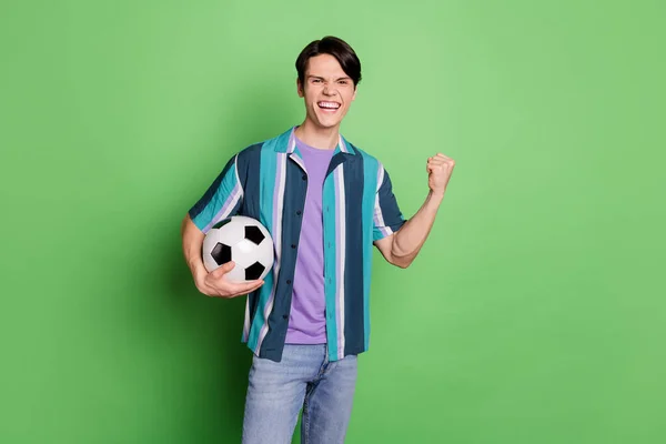 Zdjęcie radosne młody szczęśliwy człowiek trzymać za ręce zwycięzca piłki nożnej zespół odizolowany na zielonym tle koloru — Zdjęcie stockowe