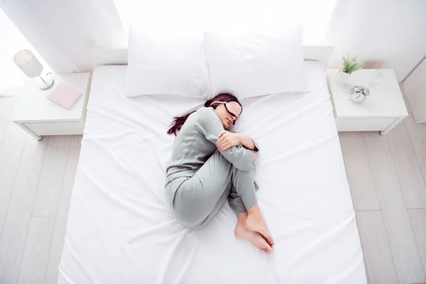 Φωτογραφία από αστείο γοητευτικό νεαρή γυναίκα γκρι μάσκα νυχτικό κάλυμμα πρόσωπο ύπνου εμβρυακή ποζάρουν χαμογελώντας σε εσωτερικούς χώρους σπίτι δωμάτιο — Φωτογραφία Αρχείου