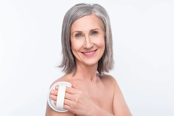 Portrait of attractive nude cheerful woman making massage daily hygiene isolated over gray pastel color background — ストック写真