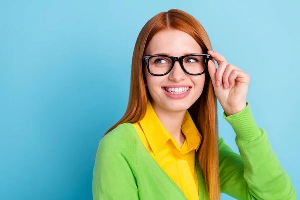 Fotografie optimistické mladé dámy vypadat prázdný prostor nosit brýle žlutý svetr izolované na modrém pozadí — Stock fotografie
