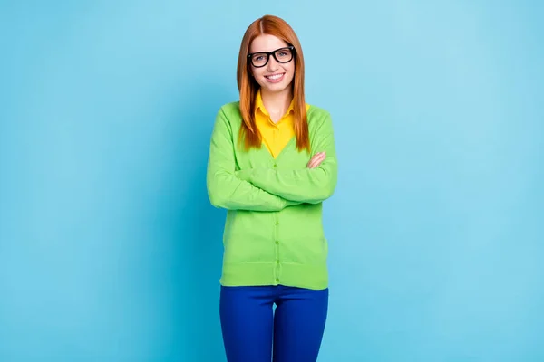 Photo of optimistic millennial orange hairdo lady crossed arms wear spectacles green sweater isolated on blue color background — ストック写真