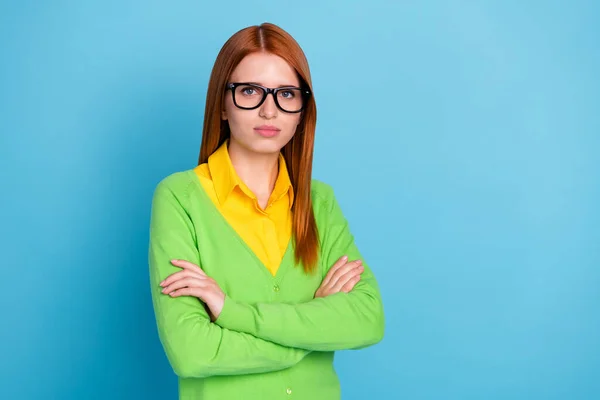 Foto de penteado laranja grave jovem professora senhora cruzou os braços usar óculos camisola verde isolado no fundo de cor azul — Fotografia de Stock