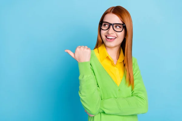 Photo of cute ginger hairdo young ceo lady point look empty space wear spectacles green cardigan isolated on blue color background — ストック写真