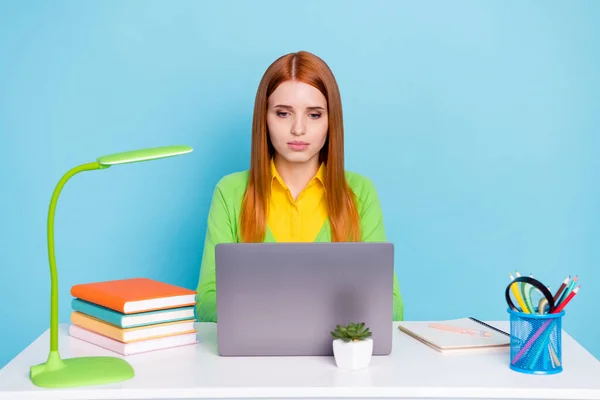 Foto van ernstige gember kapsel jonge dame werk laptop dragen groen vest werk thuis geïsoleerd op blauwe achtergrond — Stockfoto