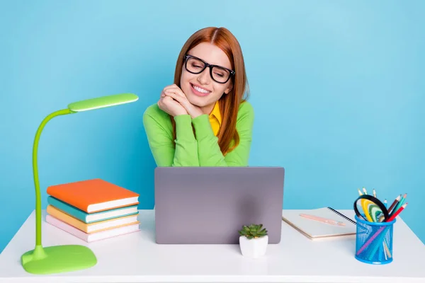 Foto de bonito gengibre penteado jovem senhora segurar as mãos olhar laptop desgaste verde cardigan trabalho de casa isolado no fundo azul — Fotografia de Stock